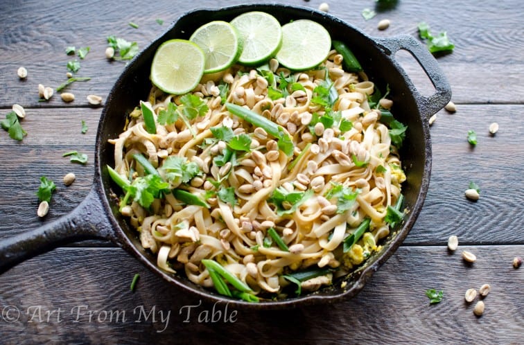 Healthy vegetable pad thai with peanuts and cilantro served in a cast iron pan.