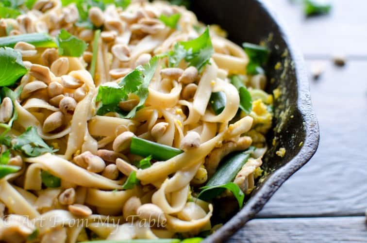 Vegetable pad thai with peanuts and cilantro in a cast iron pan.