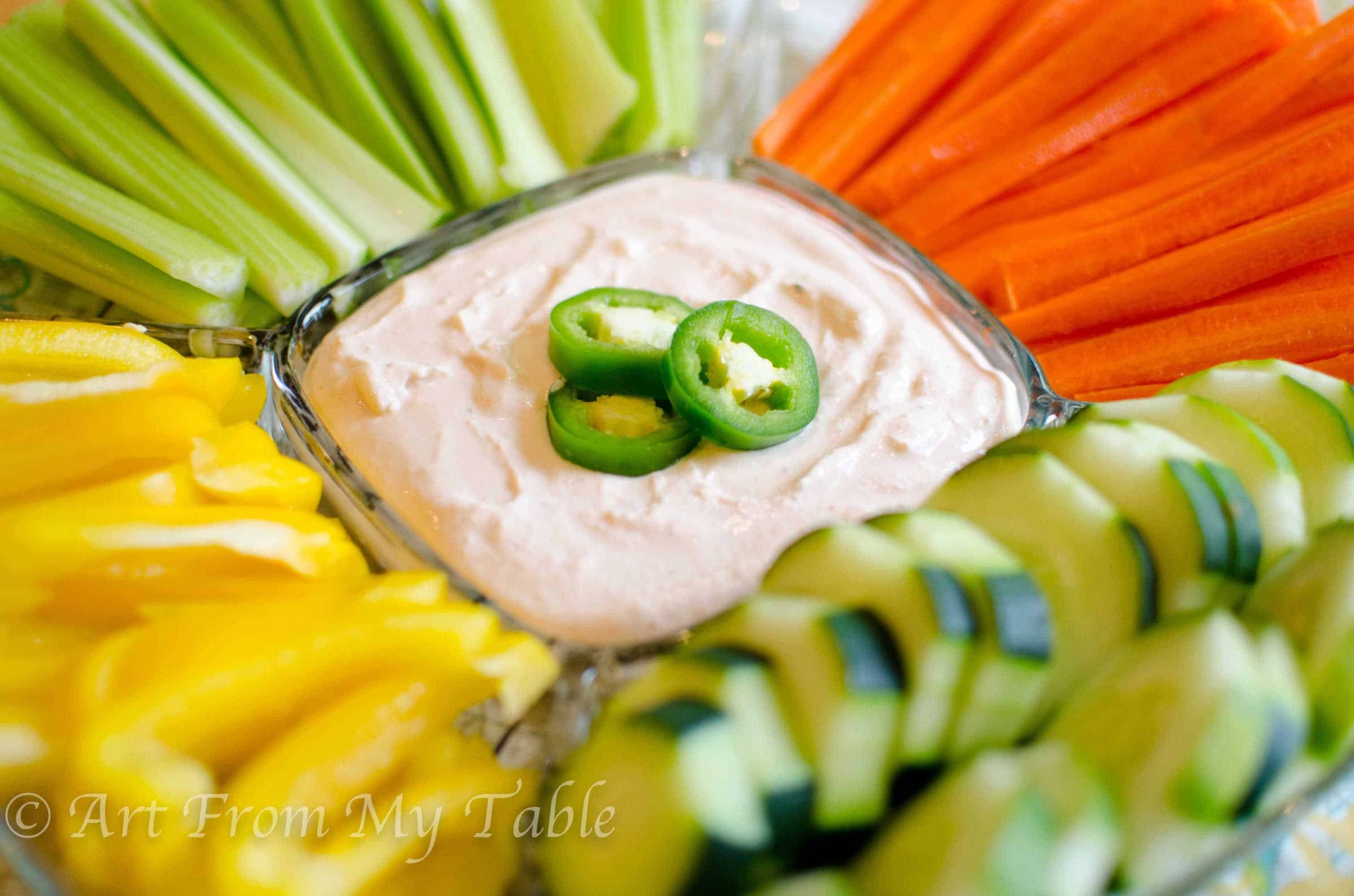 Vegetable tray with jalapeno dip in the center. 