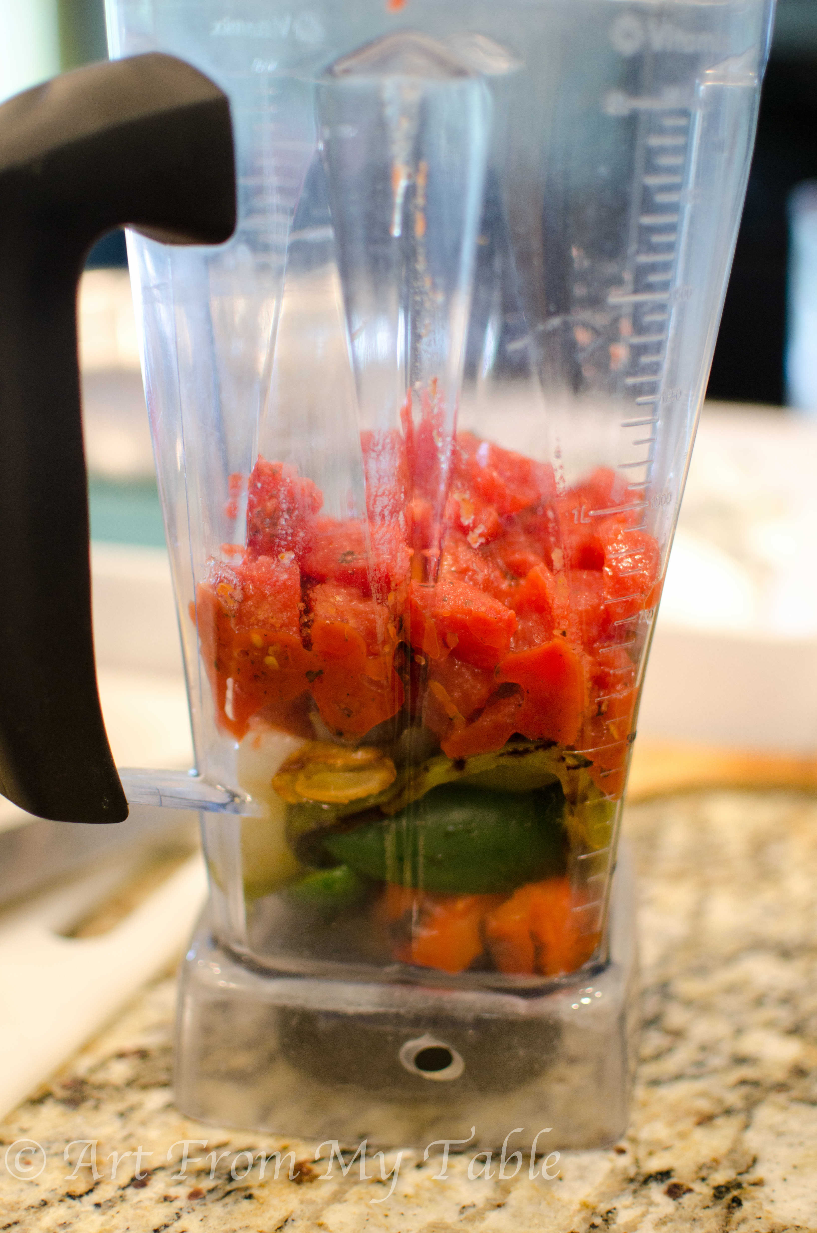 Blender with charred veggies, and diced tomatoes.