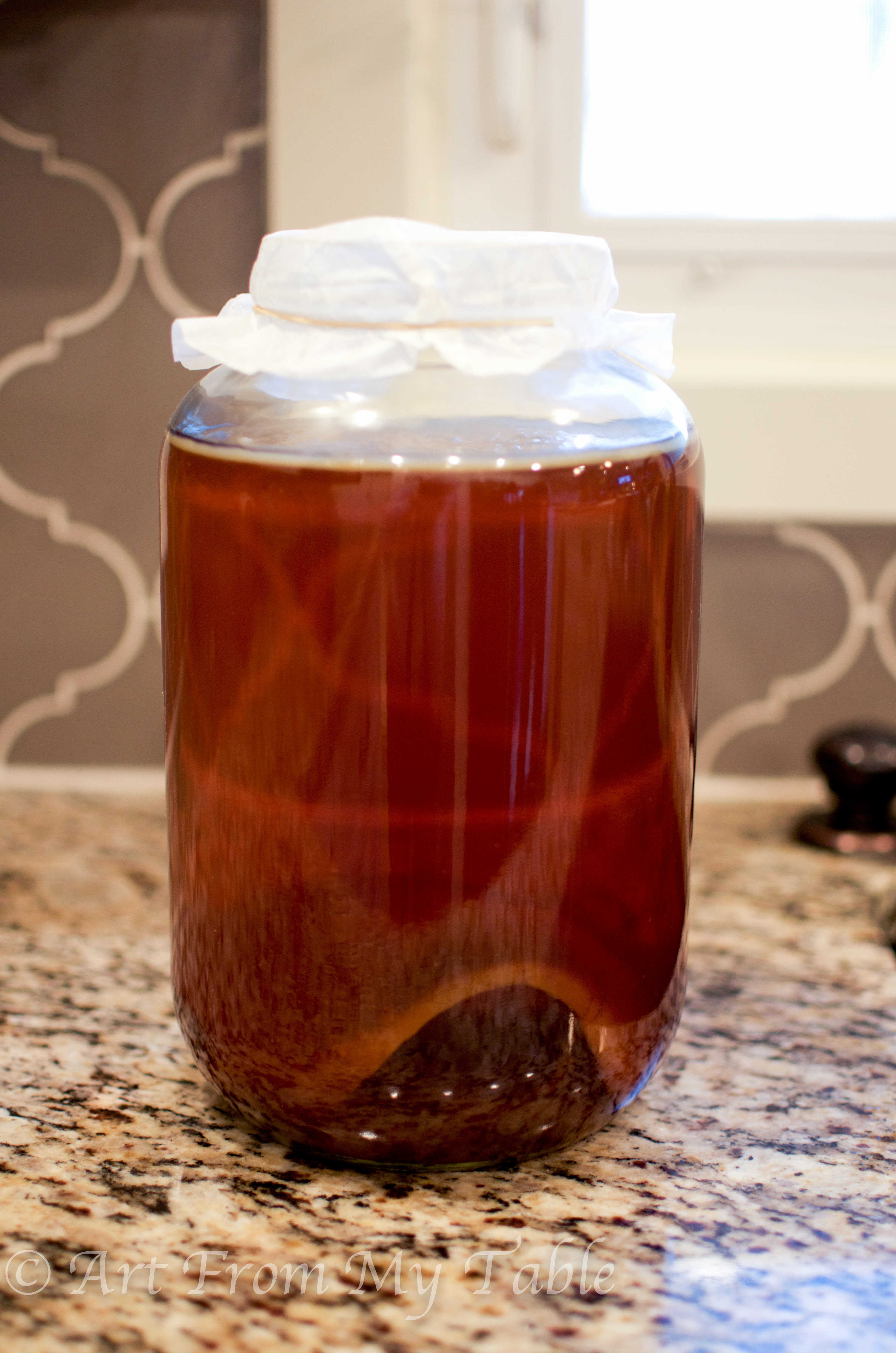 gallon size jar with starter tea and SCOBY.