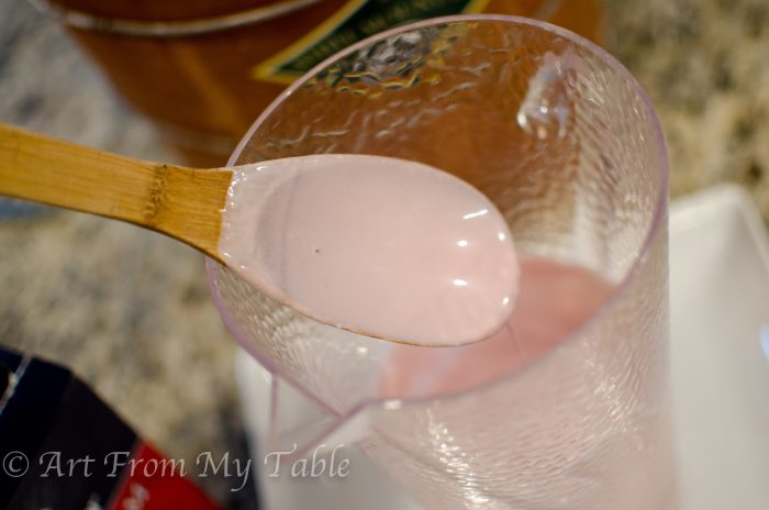 Pitcher of pomegranate juice and heavy cream stirred together.
