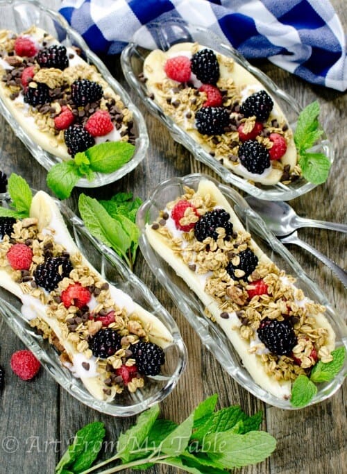Four breakfast banana splits in banana split dishes.