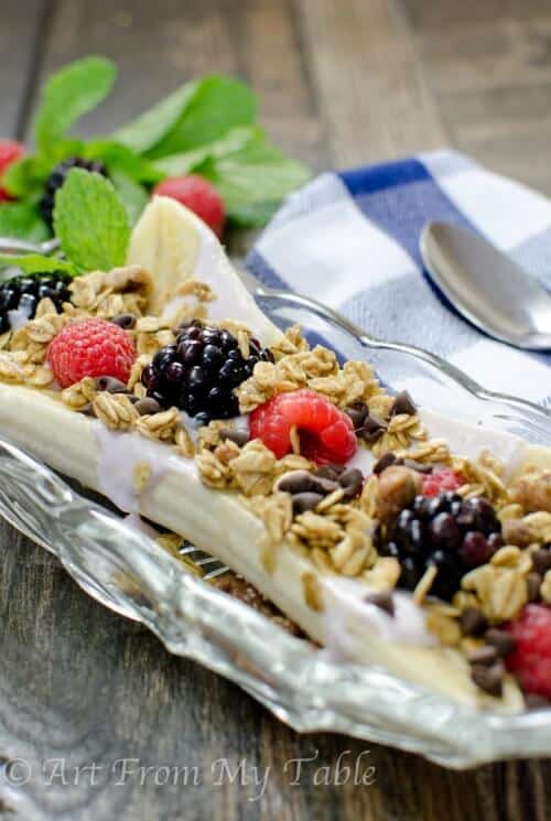 Healthy banana split with yogurt, berries, granola and chocolate chps. 