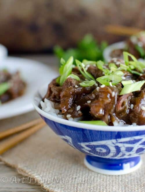Mongolian beef garnished with sliced green onions and sesame seeds.