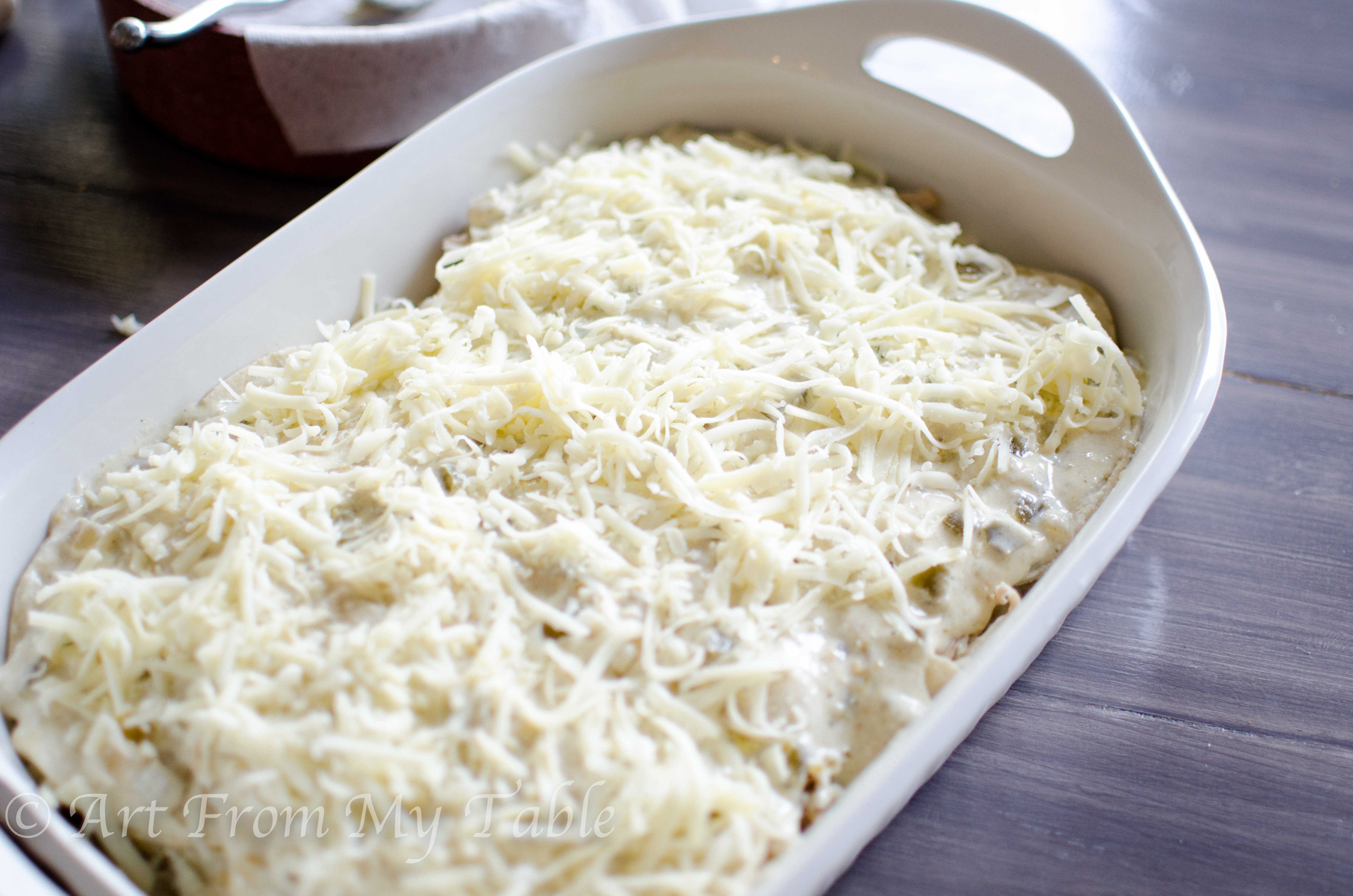 Carnitas casserole in a white dish ready to be put in the oven.