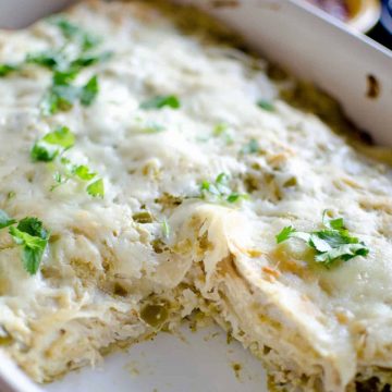baked carnitas casserole verde in a white dish with one piece removed