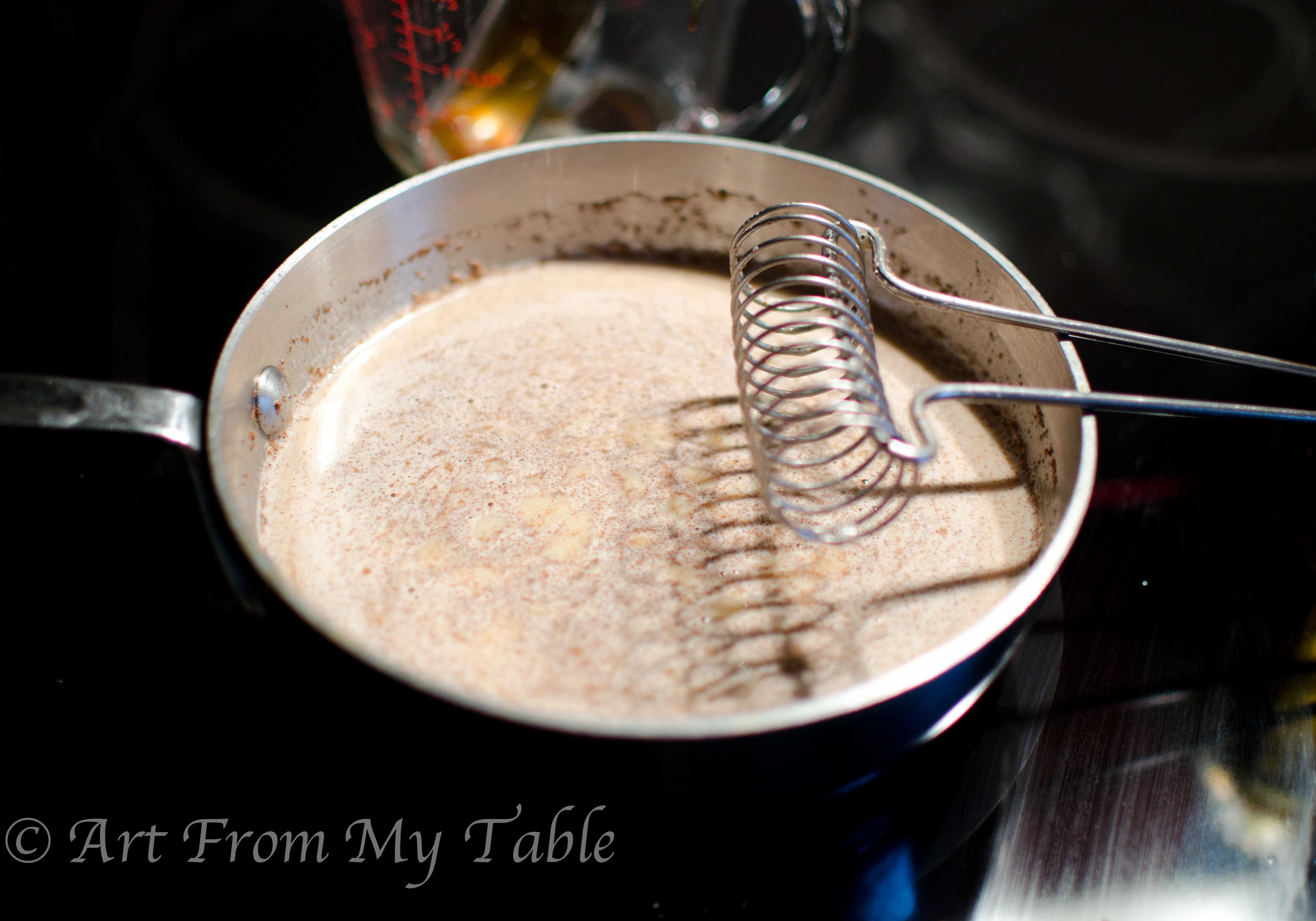 Warm milk in a pan with spices whisked in.