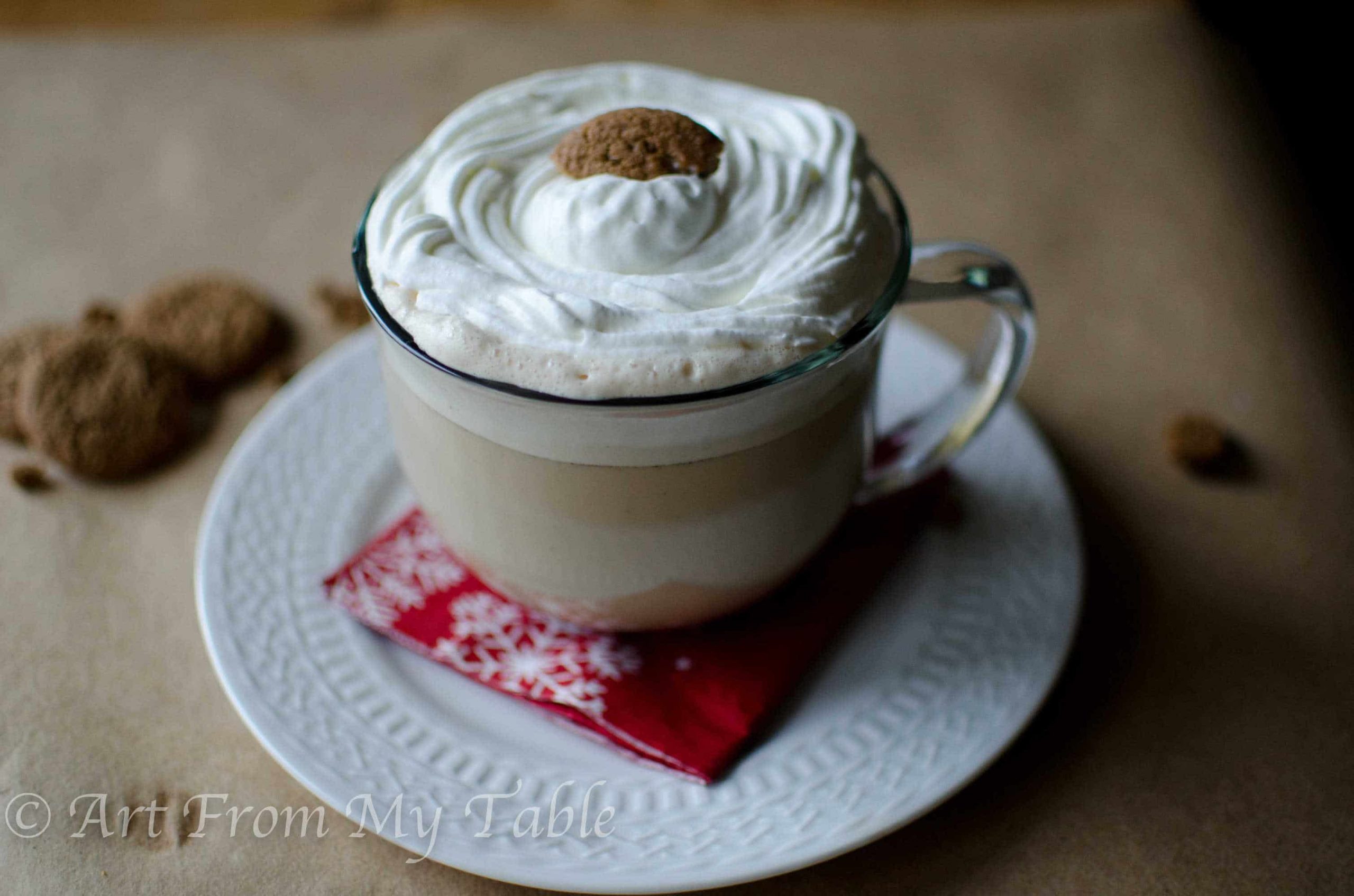 Gingersnap steamer in a glass mug, topped with fresh whipped cream.