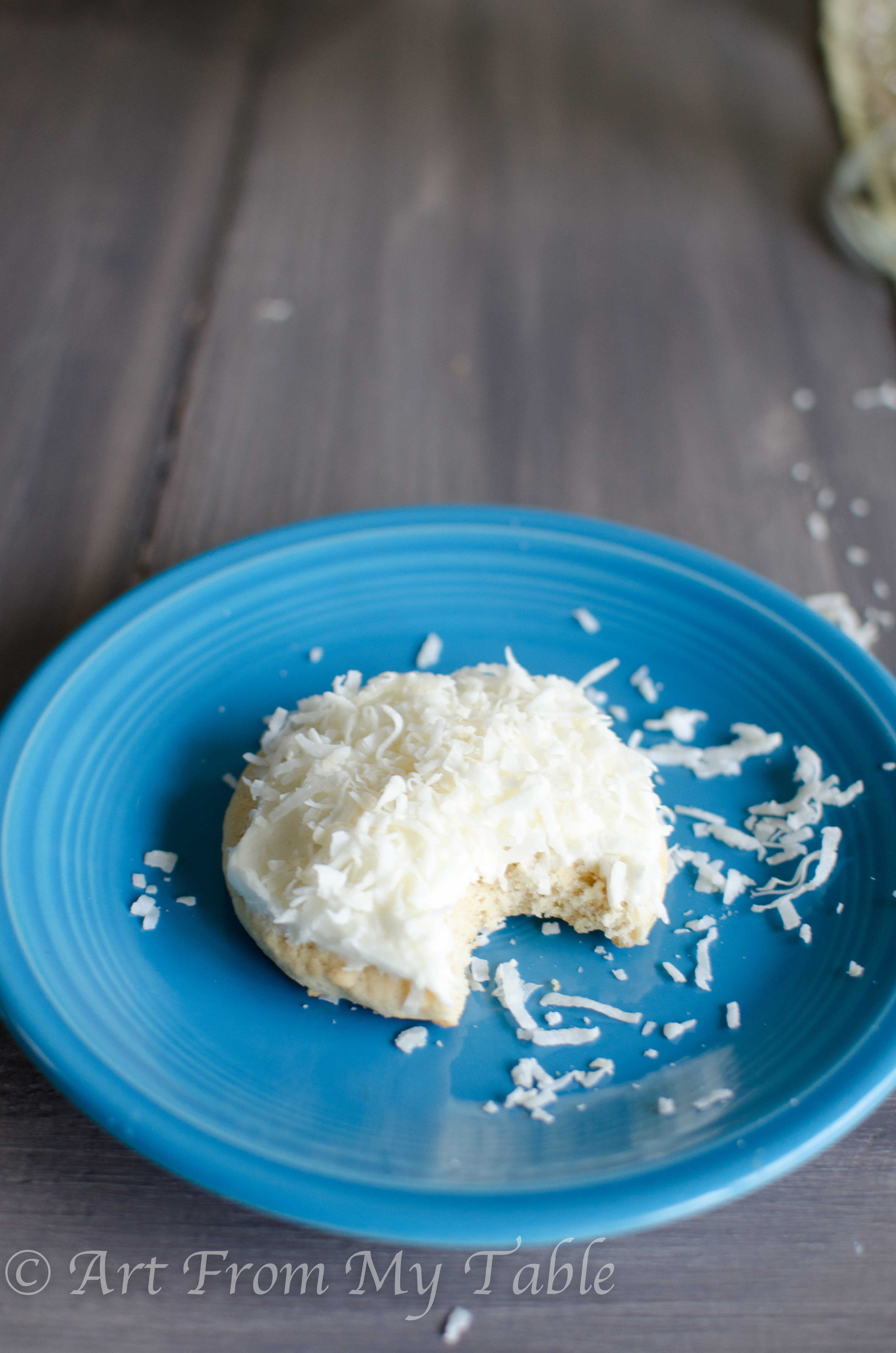 Snowball cookie with a bite taken out, on a plate.