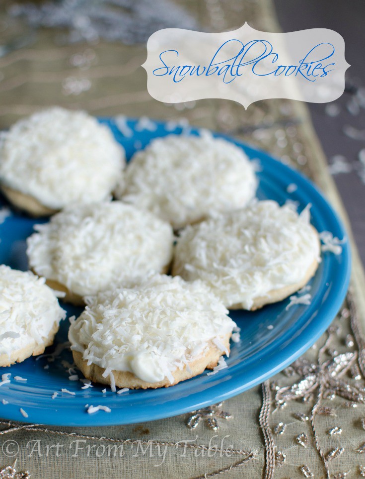 Round sugar cookies with coconut frosting and shredded coconut on a plate.