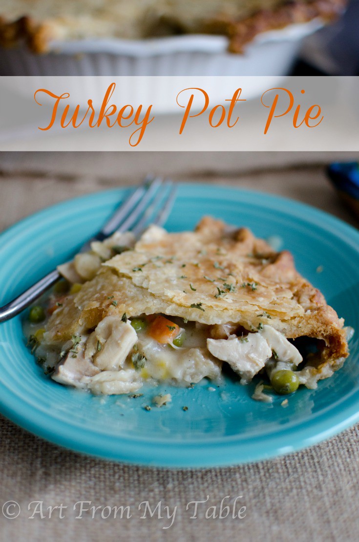 Slice of turkey pot pie on a plate, creamy sauce oozing out.