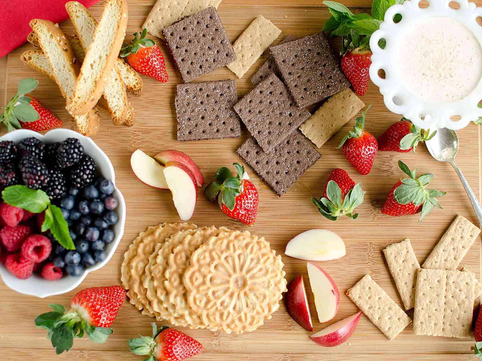 dessert board with fresh fruit, eggnog dip, and crackers for dipping.