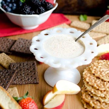 egg nog dip surrounded by graham crackers and fruit and cookies for dipping.