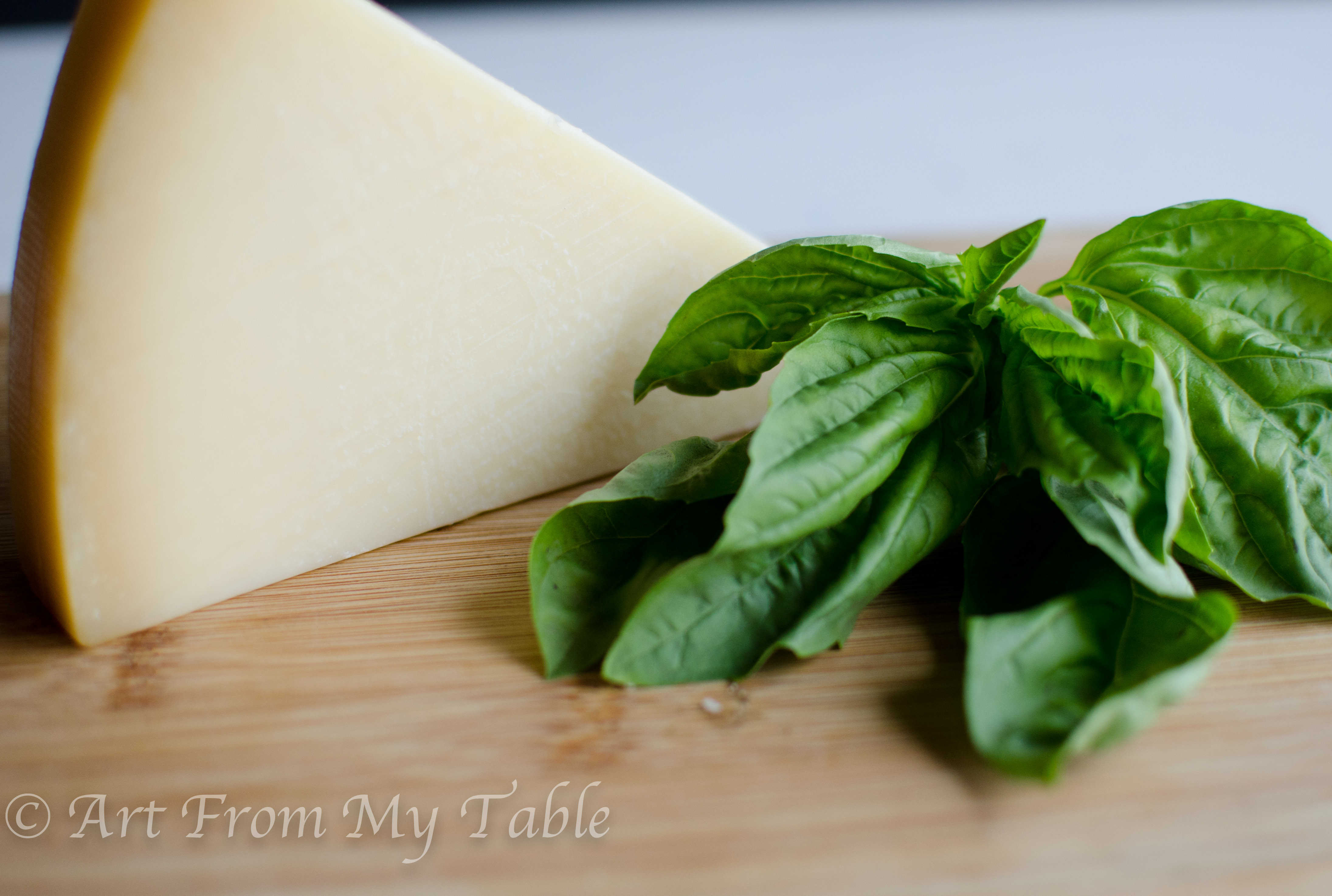 Ingredients for homemade parmesan cheese crisps, Parmesan cheese and fresh basil leaves. 