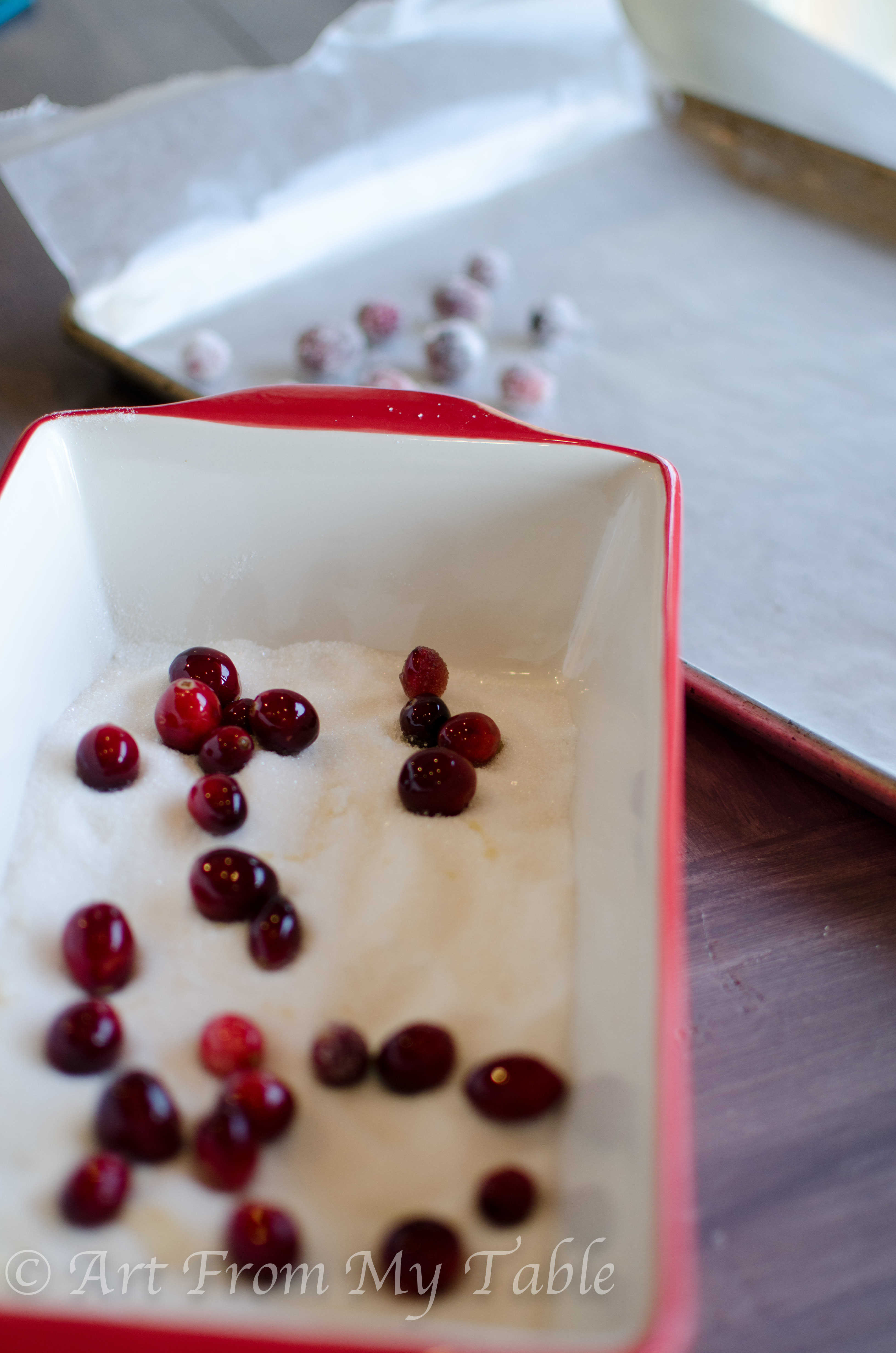 Fresh cranberries being rolled in sugar.