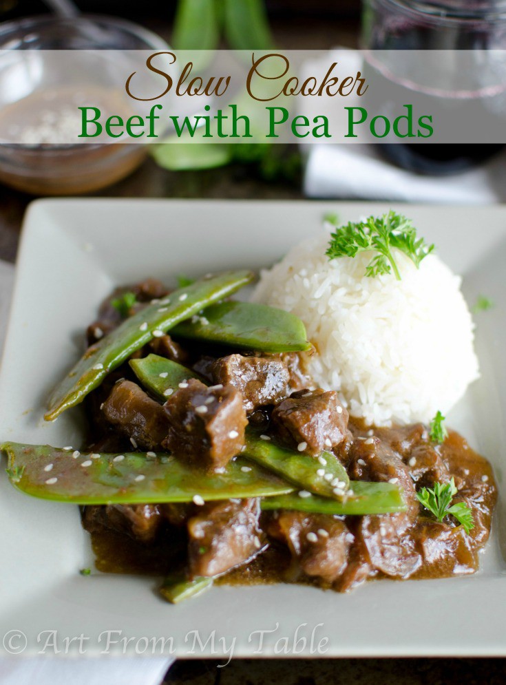 Slow cooker beef with peapods served on a plate with white rice.