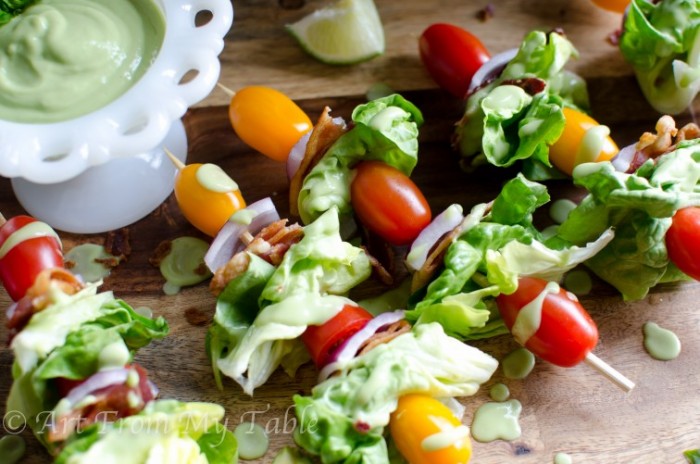 bacon, lettuce, tomato and onion threaded on a skewer for a salad appetizer.