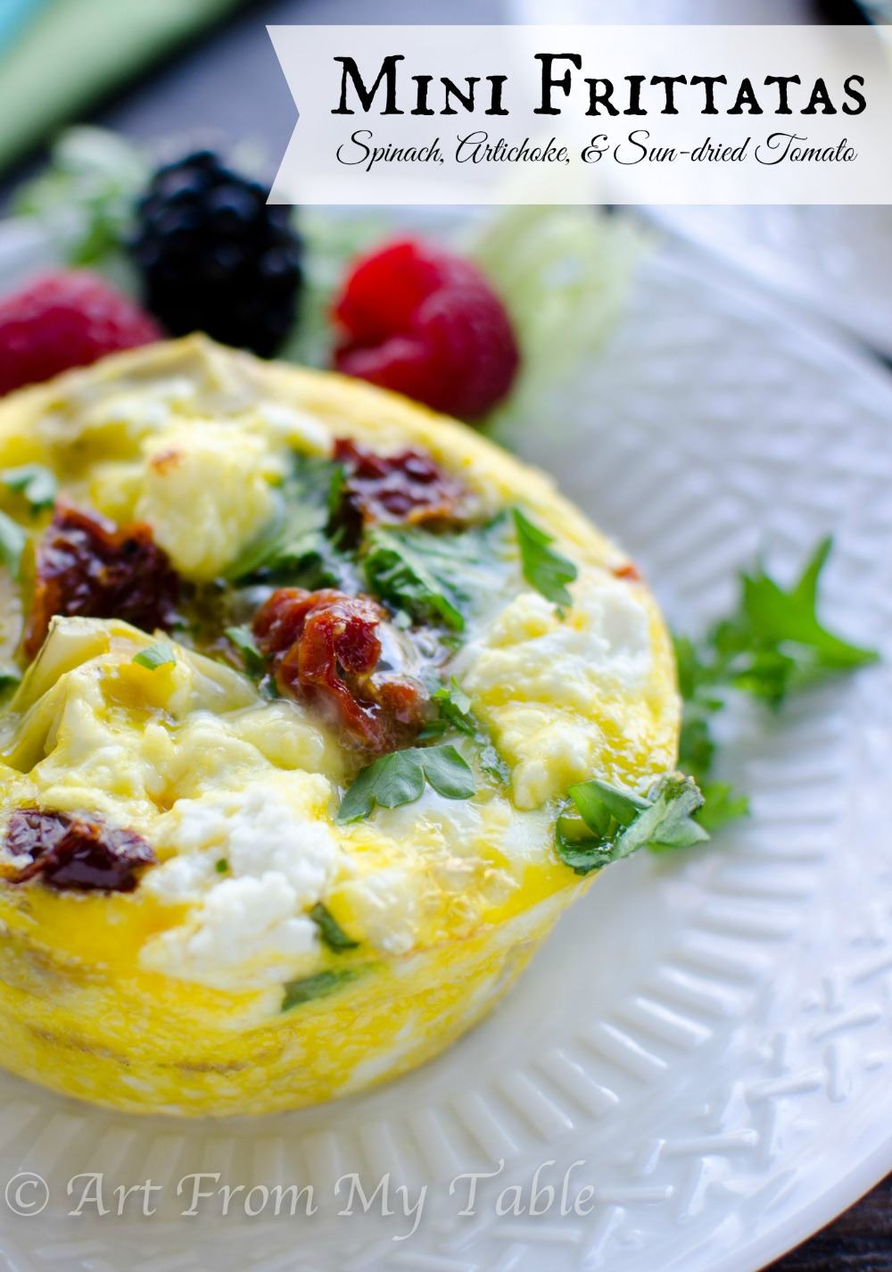 Spinach, artichoke, and sun dried tomato mini frittata on a plate.