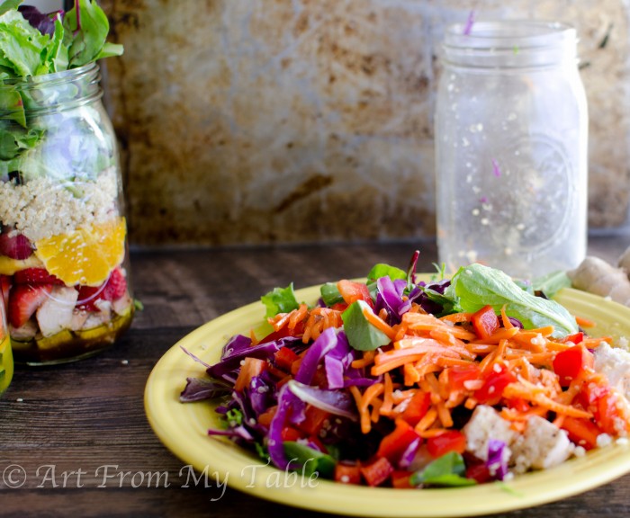 Asian Chicken salad with quino on a plate, empty mason jar behind it. 