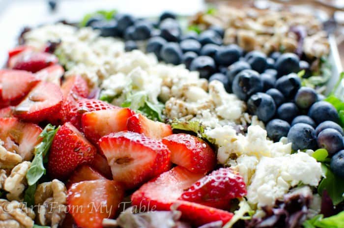 Green salad with strawberries, blueberries, feta cheese and walnuts. 