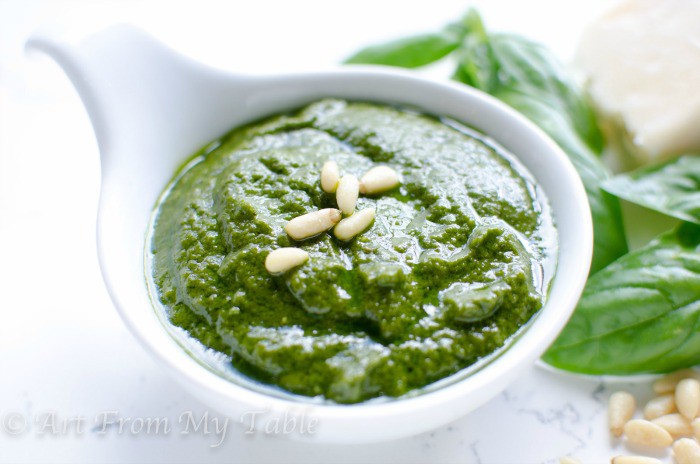 Homemade Pesto Sauce in a bowl garnished with a few pine nuts. 