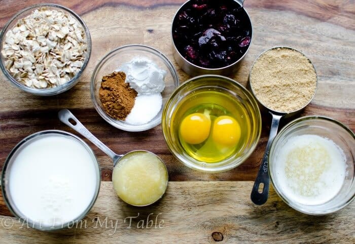 Ingredients for Baked Oatmeal: Oats, milk, butter, eggs, applesauce, brown sugar, cinnamon, and cranberries.