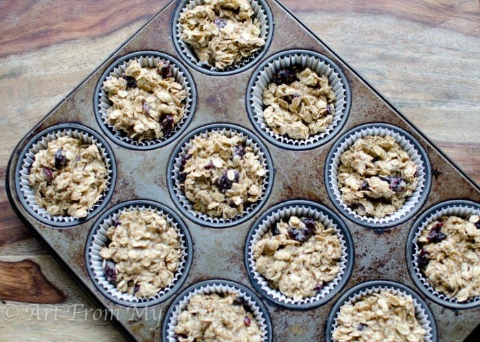 Oatmeal mixture in muffin pan wells prior to baking.