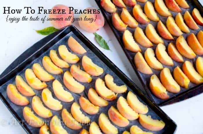 Two rimmed baking trays lined with Frozen peach slices that were flash frozen.