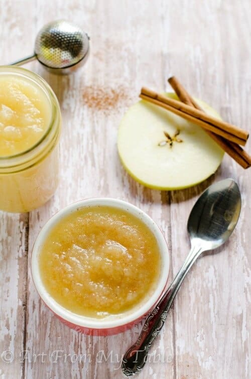 Ramekin filled with homemade applesauce, next to a jar of applesauce.