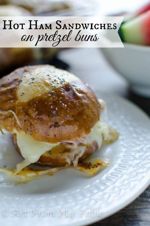 Baked ham and cheese slider on a pretzel bun.