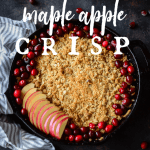 healthy maple apple crisp baked in a cast iron skillet and garnished with fresh apple slices and fresh cranberries