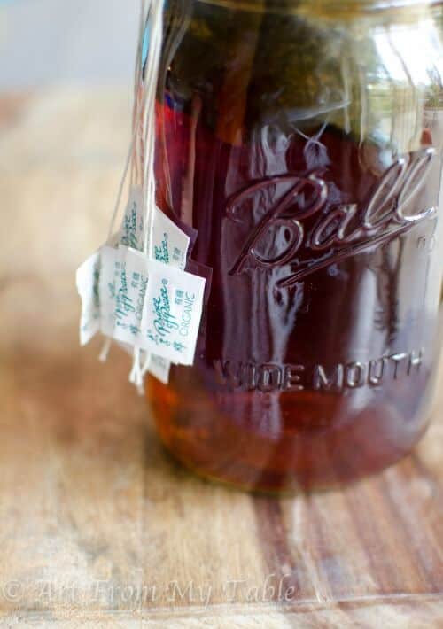Quart sized mason jar full of oolong tea bags and water.