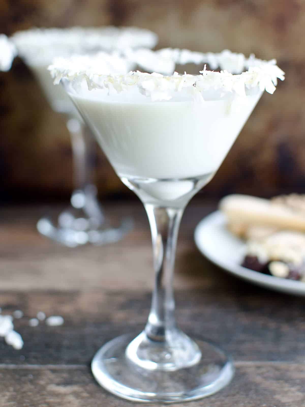 Nonalcoholic coconut creme martini in a glass rimmed in honey and coconut flakes.