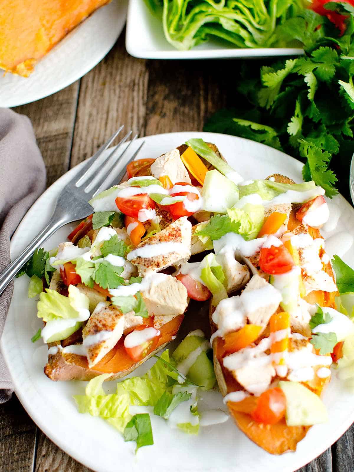 baked sweet potatoes stuffed with chicken and vegetables topped with sour cream.