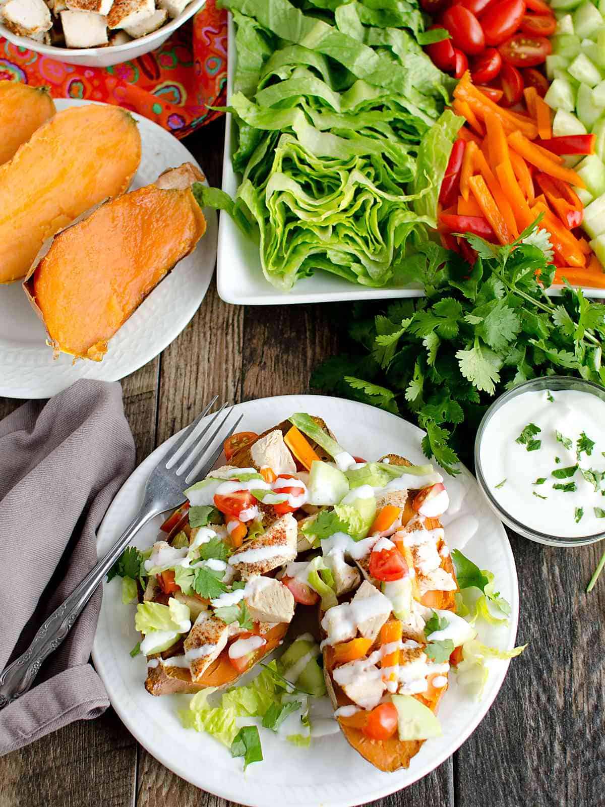 baked sweet potato sliced in half topped with seasoned chicken, lettuce, tomato, bell peppers and drizzled with sour cream.