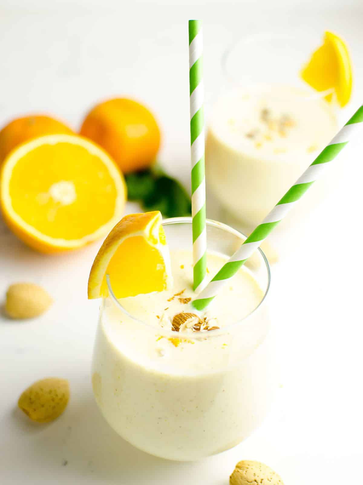 2 Orange Creamsicle Smoothie in glasses garnished with chopped almonds.