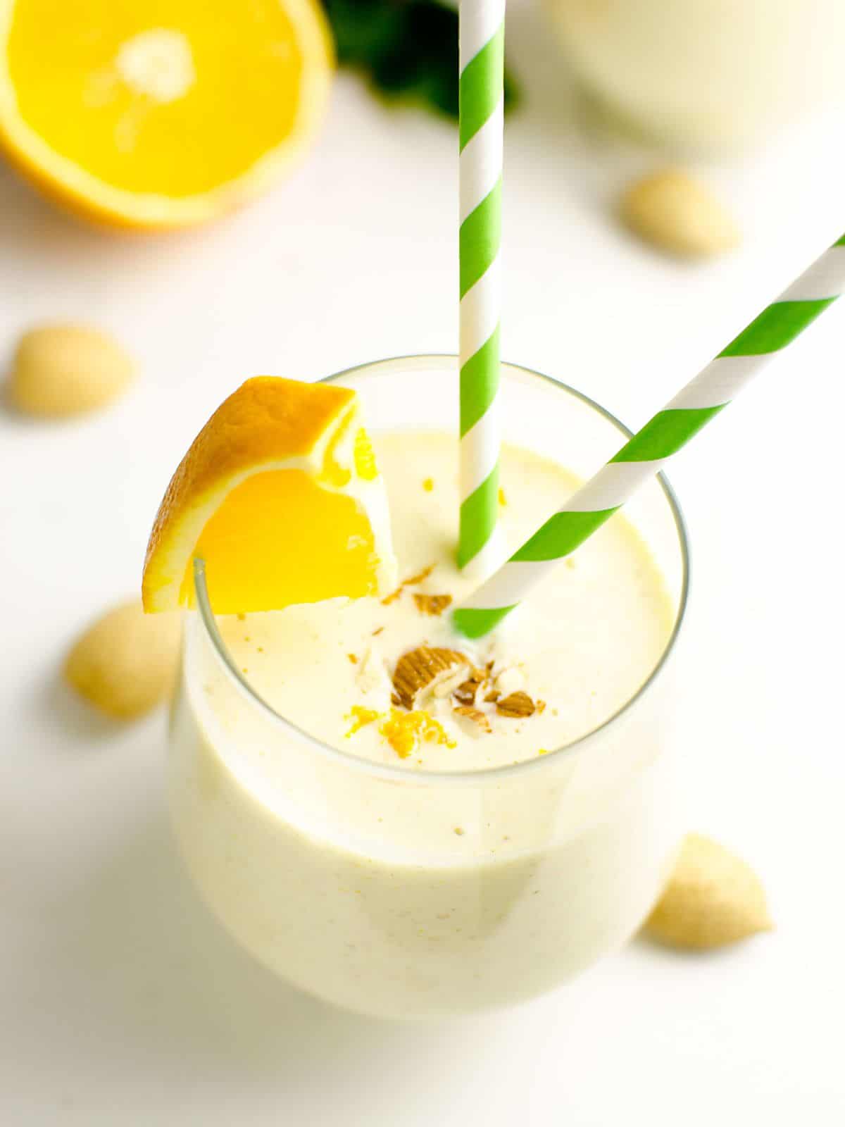 Healthy Orange Creamsicle Smoothie in a glass garnished with an orange wedge and chopped almonds.