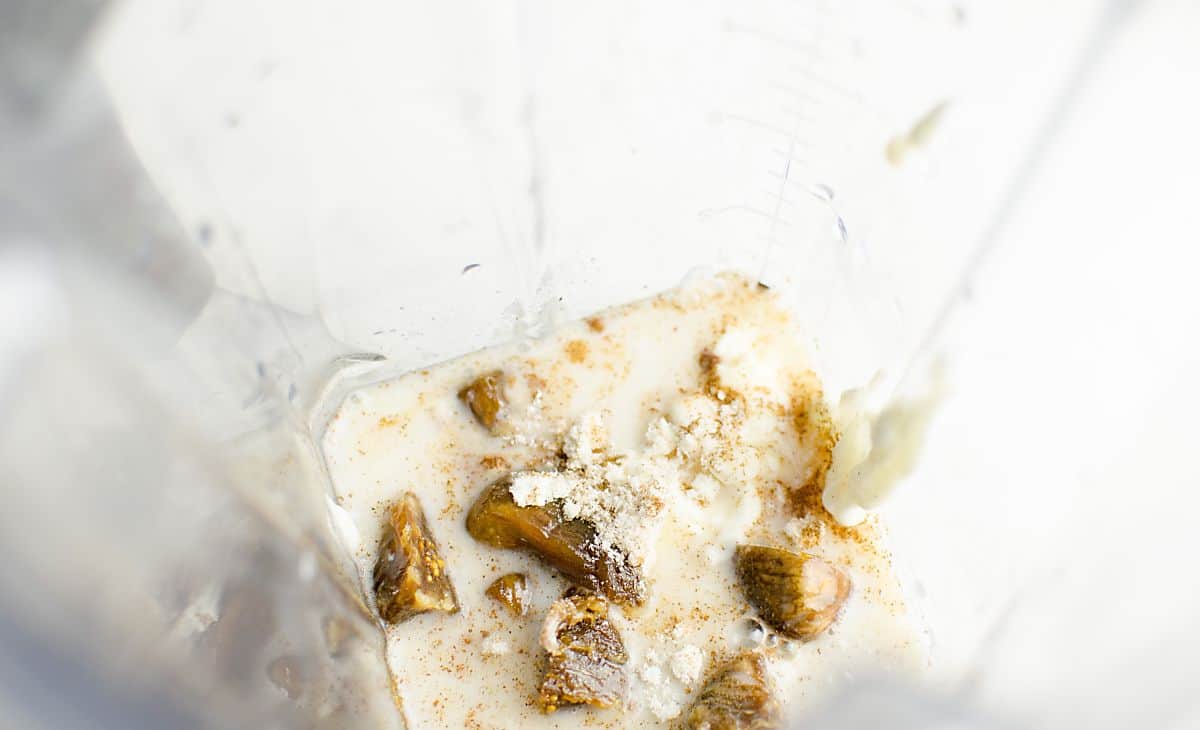 figs, almond milk, yogurt, and protein powder in a blender not blended yet.