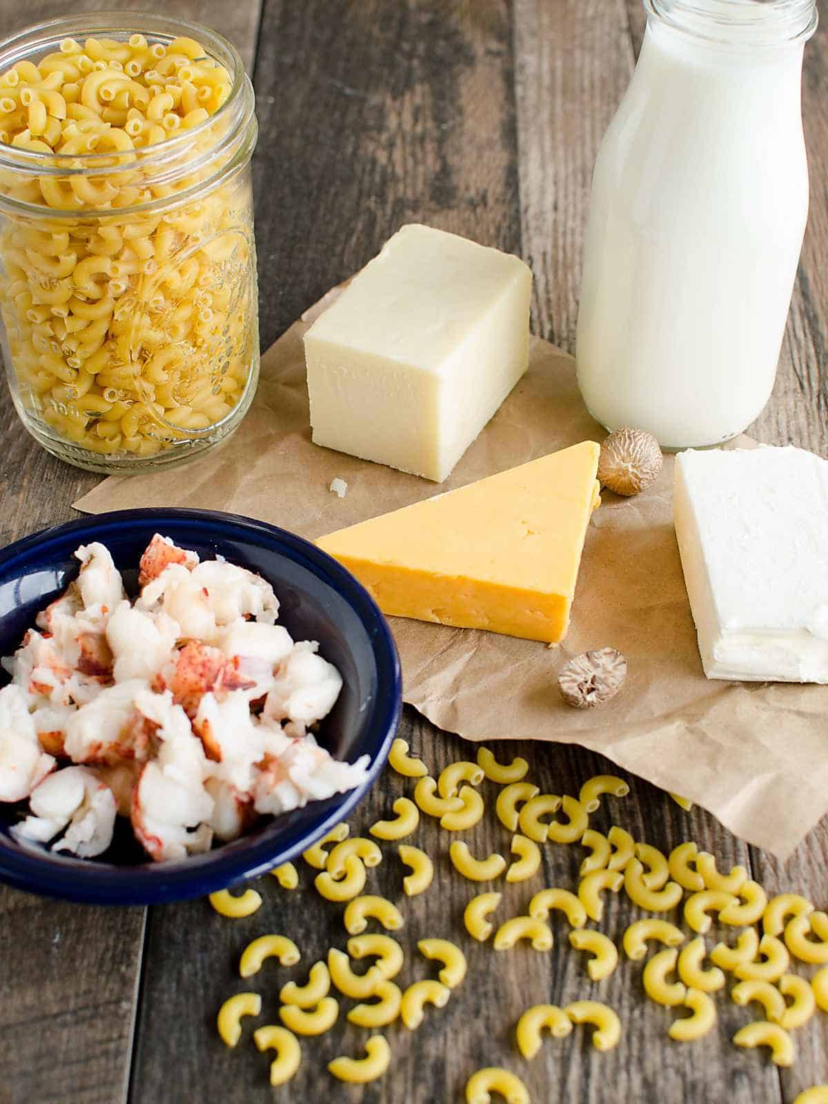 ingredients for lobster mac and cheese incuding: macaroni, 3 types of cheese, milk, and lobster meat.