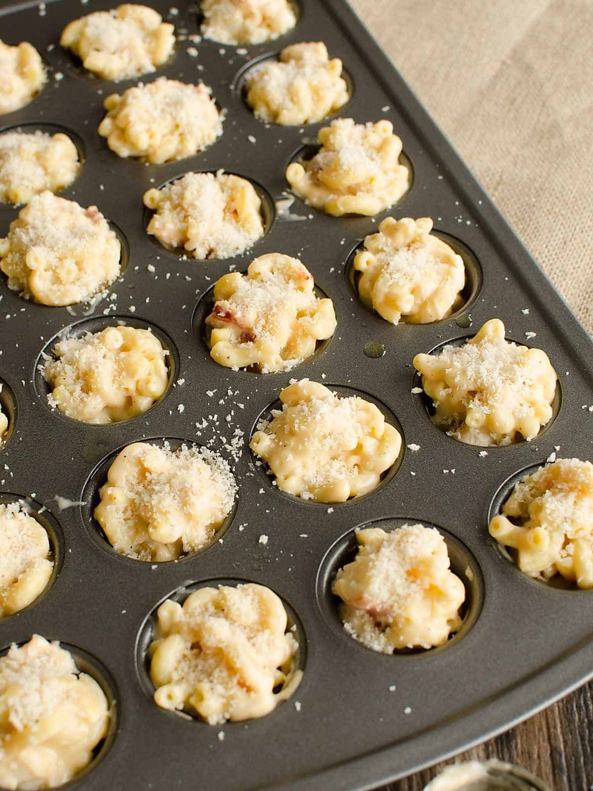 small portions of mac and cheese in a mini muffin tin with breadcrumbs sprinkled over the top prior to baking.