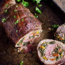 Flank steak roll stuffed with spinach peppers and blue cheese, sliced like pinwheels