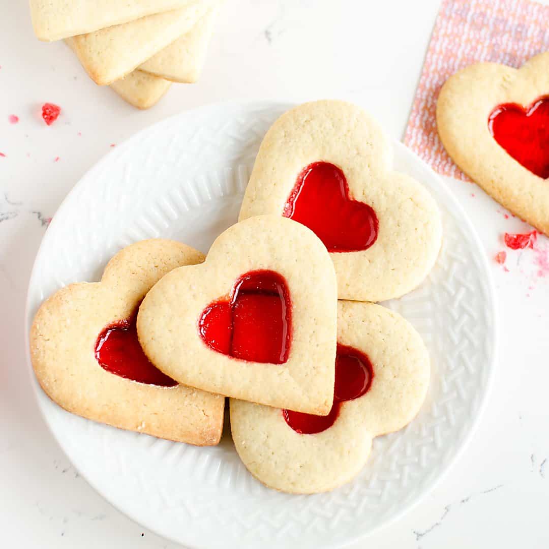 Plate of Valentine's Day sugar cookies that reveal secret messages. heart shaped, with a red 'stained glass' center