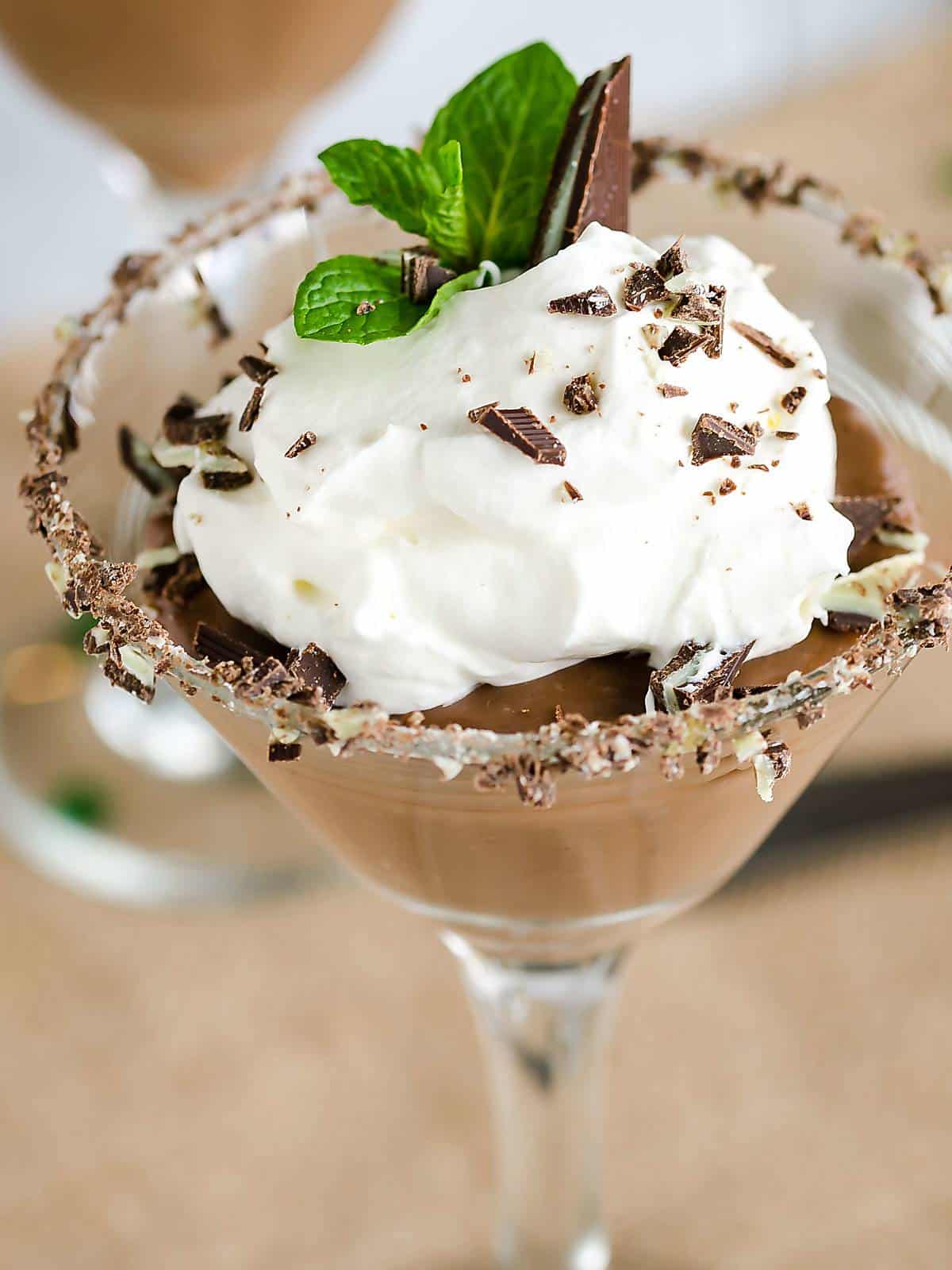 homemade bittersweet chocolate pudding served in a martini glass with whipped cream.
