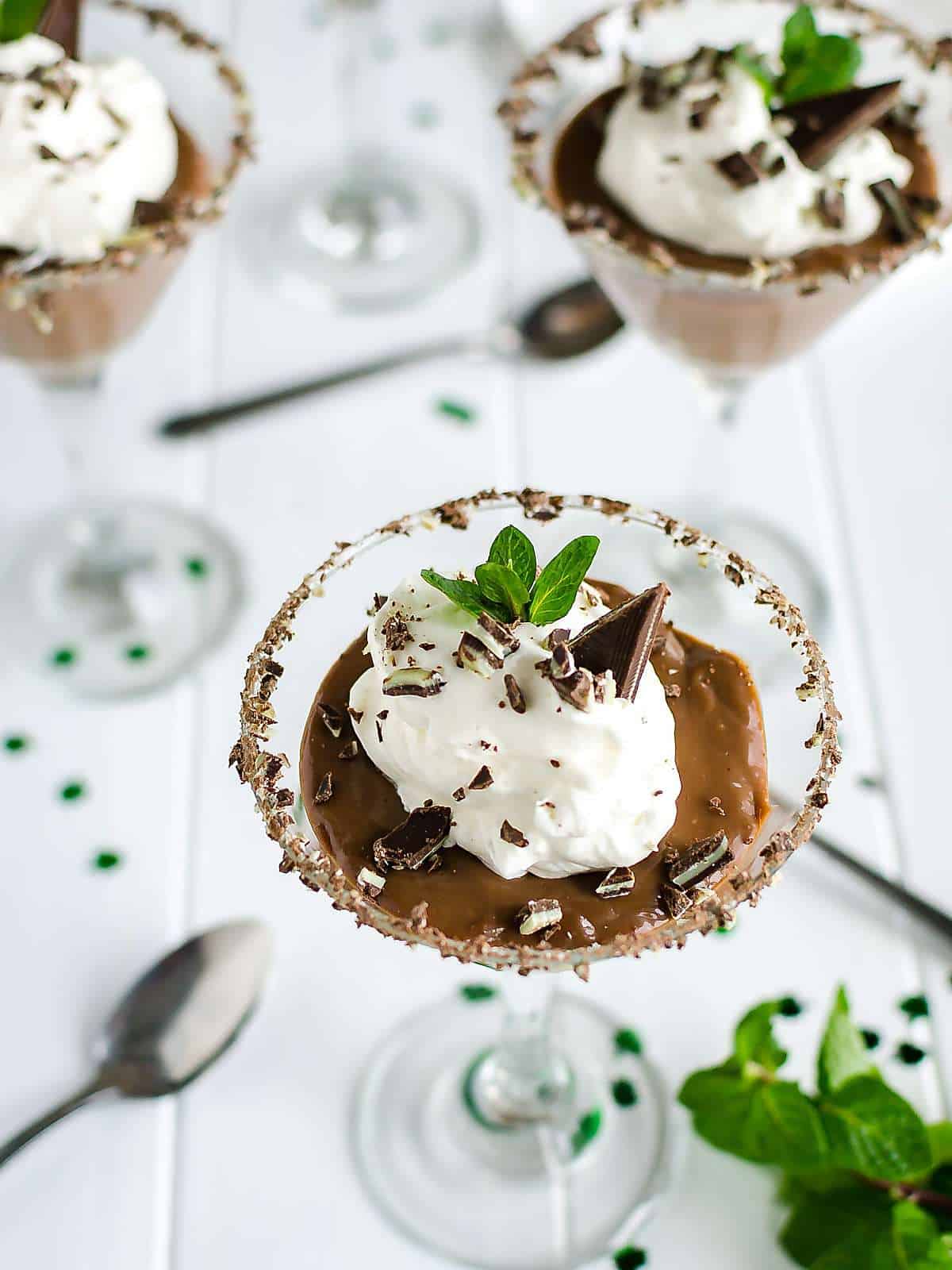 homemade chocolate pudding with whipped cream and crushed Ande's mints in a chocolate rimmed glass.