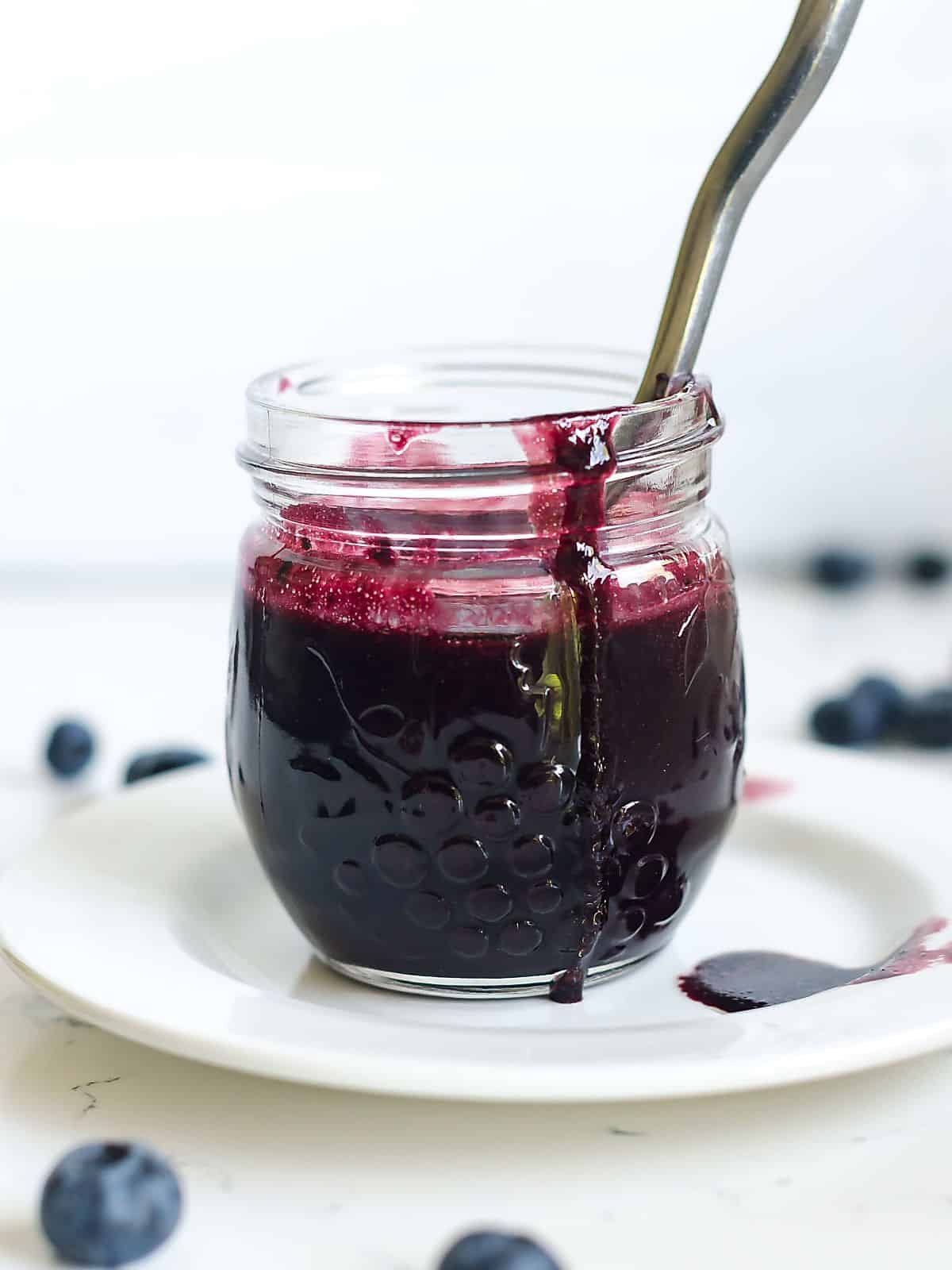 Blueberry Balsamic Vinaigrette Dressing in a glass jar with a spoon