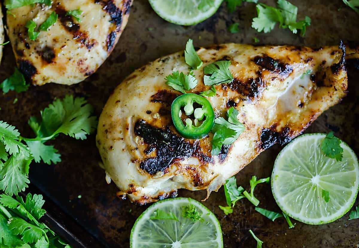 grilled chicken breast garnished with cilantro and jalapeno slice. 