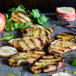 apple cider grilled pork chops with a stack of grilled apple slices