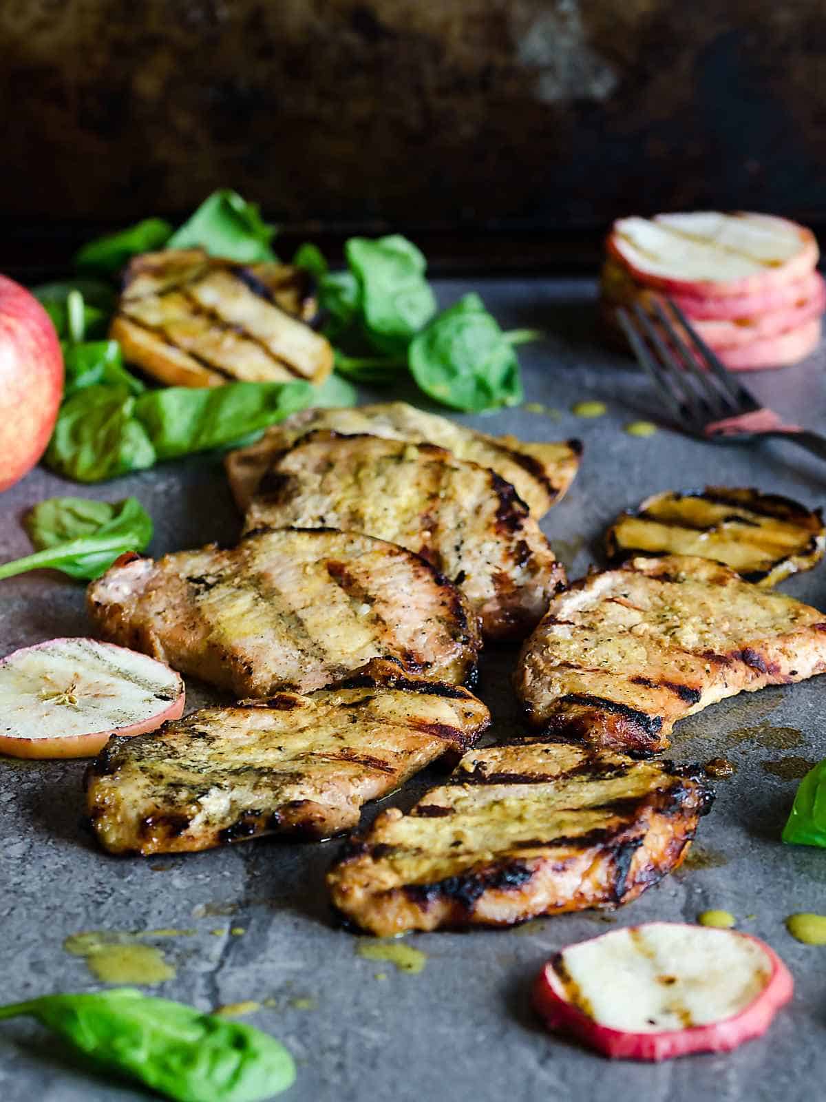 apple cider grilled pork chops with a stack of grilled apple slices