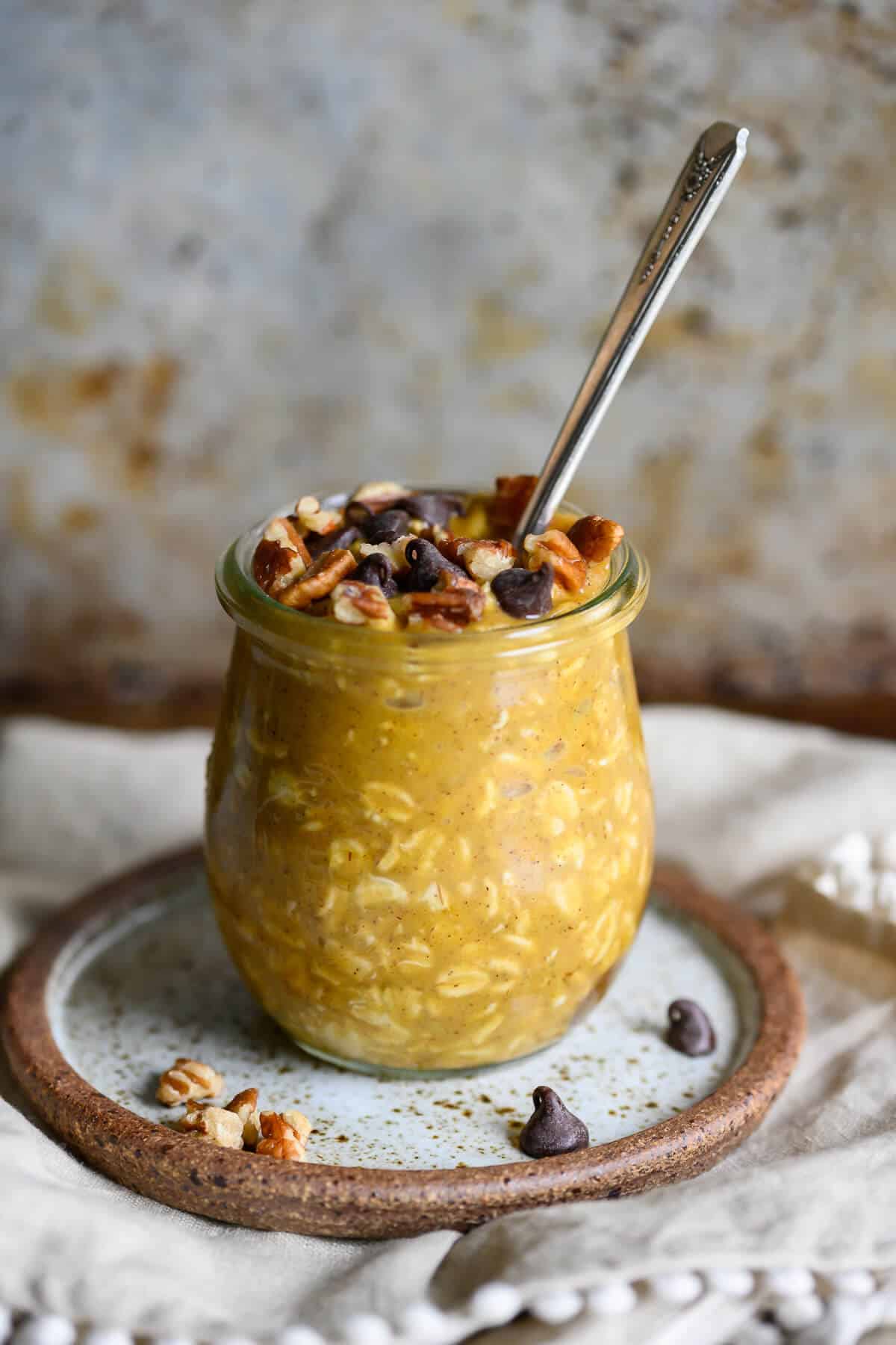 pumpkin overnight oats garnished with pecans and chocolate chips